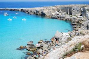 un gruppo di persone su una spiaggia in acqua di Casa dello Scoglio nel mare a Paceco