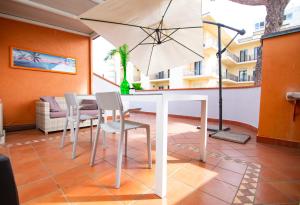 a dining room with a table and chairs and an umbrella at Prime blue suite - Giardini in Riccione