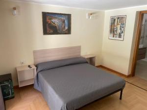 um quarto com uma cama e um quadro na parede em VILLA ARYA em SantʼAndrea