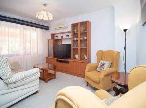 a living room with two chairs and a television at SibsSanlucar Albero - Ideal Familias - Centro - Playa Piletas in Sanlúcar de Barrameda