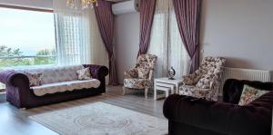 a living room with a couch and two chairs at Ayliya hause in Akcaabat