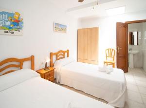 ein Hotelzimmer mit 2 Betten und einem Bad in der Unterkunft SibsSanlucar Albero - Ideal Familias - Centro - Playa Piletas in Sanlúcar de Barrameda