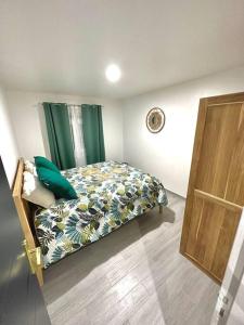 1 dormitorio con 1 cama con cortina verde en Bungalow Le Lotus Bleu avec piscine privée, en Saint-Claude