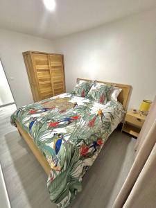 Un dormitorio con una cama con un edredón con pájaros. en Bungalow Le Lotus Bleu avec piscine privée, en Saint-Claude