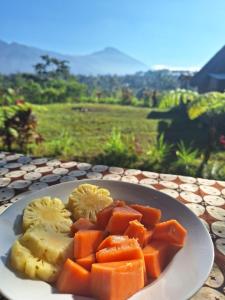 a plate of fruit and vegetables on a table at Girang Rinjani Bungalows in Tetebatu