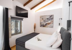 a bedroom with a bed and a tv at Villa Nika in Palaiokhóri