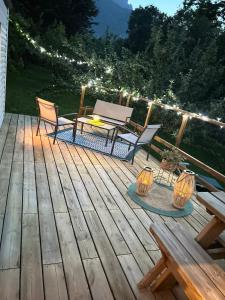 una terraza con mesa, sillas y luces en Gîte Chez Pierrot, en Vivario