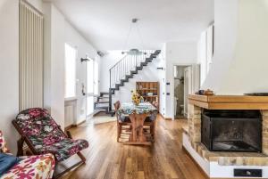un soggiorno con camino, tavolo e sedie di Villa Riviera a Levanto