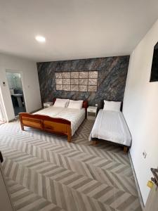 a bedroom with two beds and a stone wall at Peci Apartments in Ulcinj