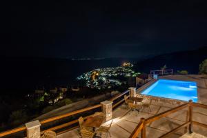 a swimming pool on the roof of a house at night at 5 Ραχες/5 Raches in Arachova