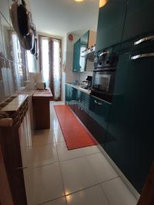 une cuisine avec des armoires bleues et un tapis rouge dans l'établissement Affreschi & Trabocchi House, à Treglio