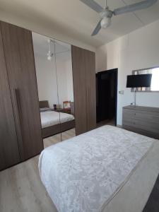 - une chambre avec un lit et un ventilateur de plafond dans l'établissement Affreschi & Trabocchi House, à Treglio