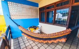 a hammock on the side of a building with a table at Pousada Casa Grande in Bonito