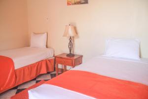 Un pat sau paturi într-o cameră la Kaiser Hotel- Negril West End