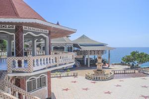 - un bâtiment avec une fontaine en face de l'océan dans l'établissement Kaiser Hotel- Negril West End, à Negril