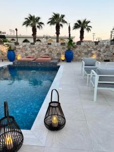 a swimming pool with two lights next to a resort at Cora May Central Villa with private pool 200m to the beach in Faliraki