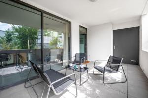 a balcony with chairs and a glass table and windows at T3 Terrasse + parking - proche Aéroport et MEET in Blagnac