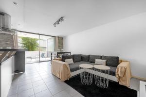 uma sala de estar com um sofá e uma mesa em T3 Terrasse + parking - proche Aéroport et MEET em Blagnac