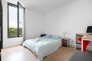 een witte slaapkamer met een bed en een raam bij T3 Terrasse + parking - proche Aéroport et MEET in Blagnac