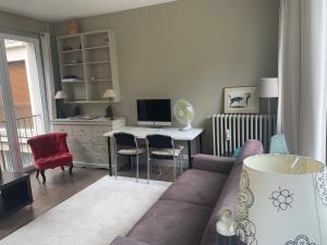 a living room with a couch and a desk with a computer at Porte Maillot-Charming and calm studio at Neuilly in Neuilly-sur-Seine