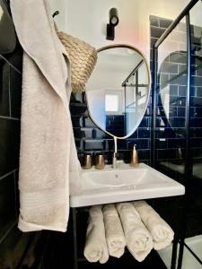 La salle de bains est pourvue d'un lavabo, d'un miroir et de serviettes. dans l'établissement Modern Couples Coastal Getaway MM, à Crikvenica