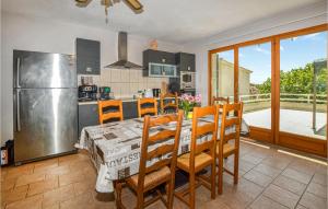 a kitchen with a table and chairs and a refrigerator at Amazing Home In Giuncaggo With Wifi in Aléria