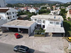 an aerial view of a white house with a car parked at Peci Apartments in Ulcinj
