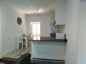 uma cozinha com um balcão e uma mesa em Acogedor apartamento a 5 minutos de Sanxenxo em Pontevedra