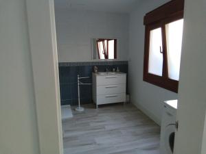 een badkamer met een wastafel en een spiegel bij Acogedor apartamento a 5 minutos de Sanxenxo in Pontevedra