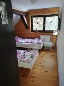 a room with three bunk beds and a window at Chata z Widokiem in Międzybrodzie Bialskie