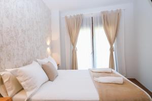 a bedroom with a white bed and a window at Villa Galicia in Caldas de Reis