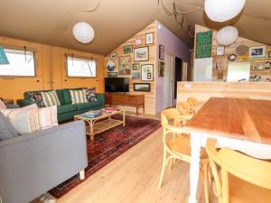 a living room with a green couch and a table at Lucky Clucky Lodge in Llandudno