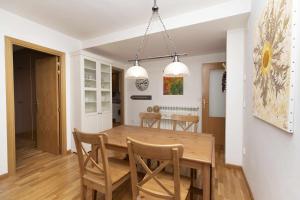 Il comprend une cuisine et une salle à manger avec une table et des chaises en bois. dans l'établissement Casa Eguzkilore by BeValle, à Escarrilla