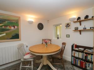 een eetkamer met een houten tafel en stoelen bij The Cottage in Highbridge