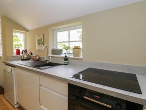 a kitchen with a sink and a stove at The Cottage in Highbridge