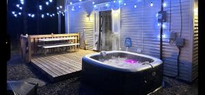 a jacuzzi tub sitting on a deck next to a building at Comtemporary, Confortable, Well Appointed Home. in Tobyhanna +49 photos