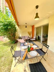 einen Tisch und Stühle mit Essen auf der Terrasse in der Unterkunft Cashmere, Aix en Provence grand T2 avec jardin en ville in Aix-en-Provence