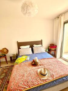 ein Schlafzimmer mit einem Bett mit Hut darauf in der Unterkunft Cashmere, Aix en Provence grand T2 avec jardin en ville in Aix-en-Provence
