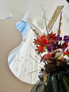 Un jarrón con flores en una habitación con luz en FAR WEST, en Ginosa
