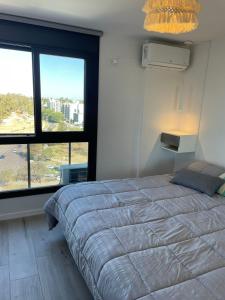 a bedroom with a large bed and two large windows at Betania Plaza in Cordoba
