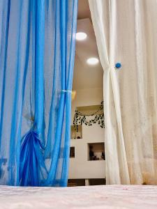 1 cama con cortinas azules y blancas en una habitación en FAR WEST, en Ginosa
