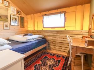 a small room with a bed and a table and a window at Mad Molly Lodge in Llandudno