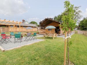 un patio con sillas, una mesa y una casa en Mad Molly Lodge en Llandudno