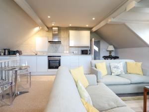 a living room with a couch and a kitchen at Rock House Apartment in Newtown