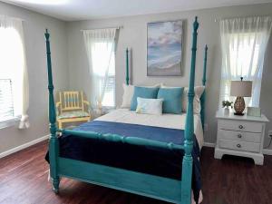 - une chambre dotée d'un lit avec un cadre bleu dans l'établissement Cozy Coastal Cottage in Heart of St. Augustine, à Saint Augustine