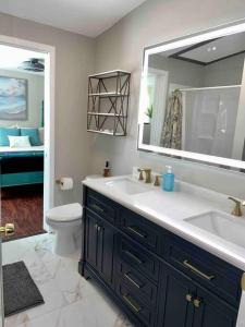 La salle de bains est pourvue d'un lavabo, de toilettes et d'un miroir. dans l'établissement Cozy Coastal Cottage in Heart of St. Augustine, à Saint Augustine