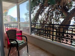 d'un balcon avec une chaise, une table et un arbre. dans l'établissement Golden Apartment Petrovac, à Petrovac na Moru
