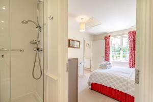 イースト・ディーンにあるFolly Cottageのシャワー付きのベッドルーム1室、ベッド1台が備わるベッドルーム1室を提供しています。