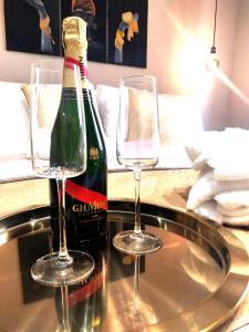 a bottle of champagne and two glasses on a table at Ti Scialíi Suites Rooms and Relax in Pachino