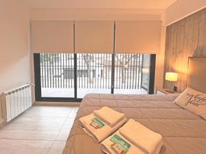 1 dormitorio con 1 cama grande y toallas. en Parque Pueyrredon V en Mendoza